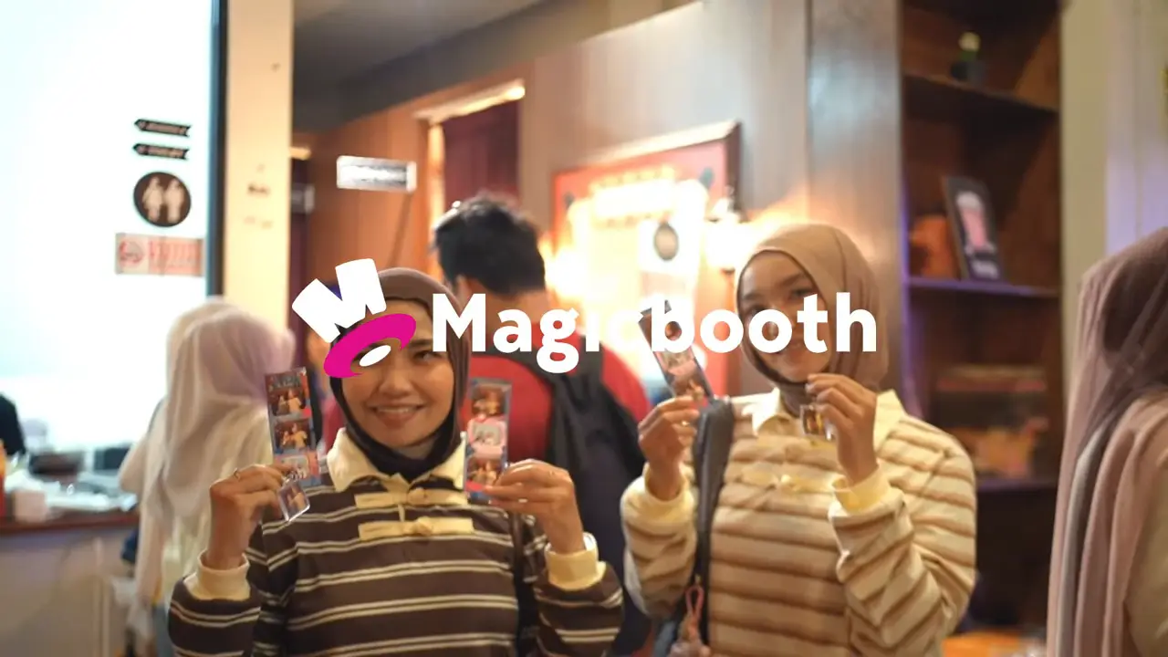 Pengunjung memegang photostrip Magicbooth